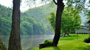 A serene lakeside setting with lush greenery and a building in the background.