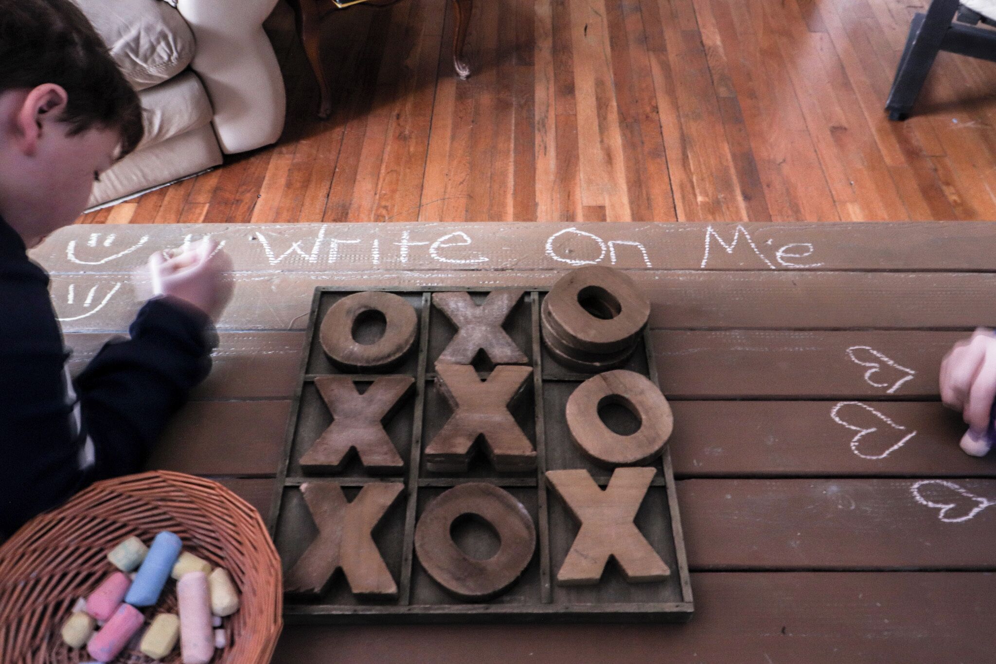 Eine Holztafel mit Kreidebuchstaben, die den Schriftzug 'Write On Me' bilden, und Holzlettern.