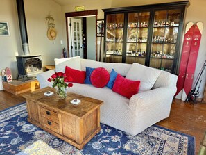 A cozy living room with a sofa, coffee table, and a fireplace.