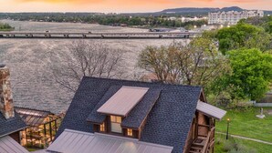 En rustik bygning i sommerhusstil med en overdækket terrasse og en trappe op til en altan.