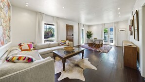 Un salon spacieux avec un canapé, une table basse et un tapis.