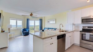 A modern kitchen with white cabinets, a granite countertop, and stainless steel appliances. - Bright & Sunny Suite w/ Magnificent Ocean Views (Tavernier)
