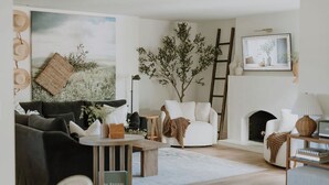 A living room with a sofa, armchair, coffee table, and a fireplace.