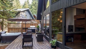 Una terraza con mobiliario exterior, un jacuzzi y una parrilla.