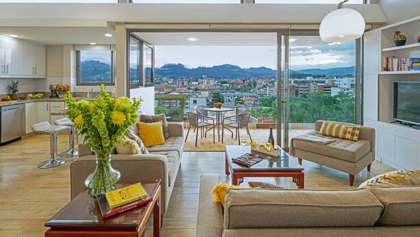 Um apartamento moderno com varanda, área de jantar e cozinha.