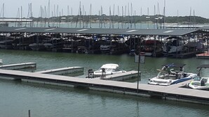 Un port de plaisance avec de nombreux quais et des bateaux, un panneau de signalisation indiquant un arrêt obligatoire, et un ciel dégagé.