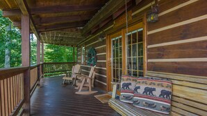 A wooden cabin with a porch, rocking chairs, and a Christmas tree. - Cloud Nine: Charming Mountain Cabin, Amazing Views!  Now featuring a new bed! (Sevierville)