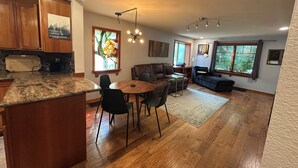 Un grand espace de vie comprenant une cuisine, une table à manger et un coin salon.