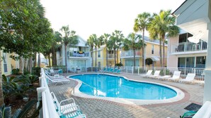 A pool area with lounge chairs and palm trees.