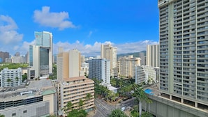 Un hôtel de grande hauteur, avec de nombreux étages, une piscine sur le toit et une vue sur le paysage urbain.