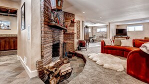 A spacious living room with a brick fireplace, a red sofa, and a fur rug.