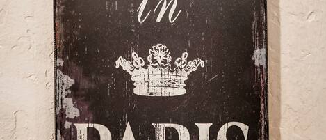 A weathered sign with the text "Evening in Paris" and a crown illustration.