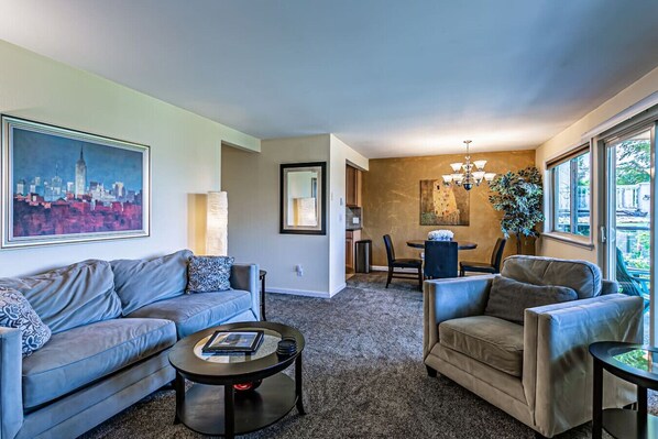 A living room with a sofa, armchairs, a coffee table, and a dining area with a chandelier. - the Veranda, Best Area, 2 Baths, WD, Jacuzzi bath (Tacoma)