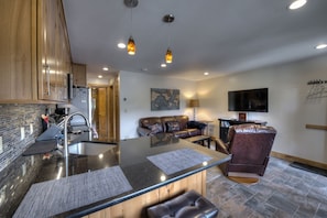 Relax in this stylish living space with a central island, leather sofa, and flat-screen TV.