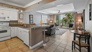 Una cocina moderna con armarios blancos, microondas integrado y una isla central.