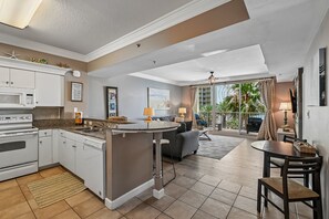 A modern kitchen with white cabinets, a built-in microwave, and a central island.