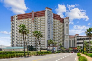 A multi-story hotel with a prominent tower, a parking garage, and a street with palm trees. - 4th Flr 1 Bdrm+Bunks/2Bath. Upgraded! Sleeps 6 (Panama City Beach)