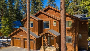 Una cabaña de madera con varias habitaciones, una escalera de piedra y vistas al bosque circundante.
