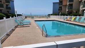Uma área de piscina com espreguiçadeiras e um aviso de 'Não Fumar'.