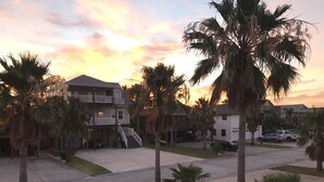 A residential area with multi-story houses, a central staircase, and palm trees. - Twelve Palms-Pet Friendly, Golf Cart Zone, Close to Beach, Downtown, City Pool  (Port Aransas)
