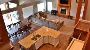 A spacious living area with a kitchen island, dining table, and seating. - PERFECT LOCATION-Walking distance to beach, restaurants, pickleball, activities! (Garden City)