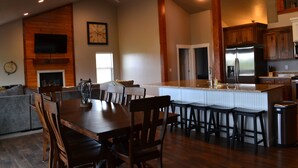 A spacious kitchen with a large island, wooden cabinets, and a stainless steel refrigerator. - PERFECT LOCATION-Walking distance to beach, restaurants, pickleball, activities! (Garden City)
