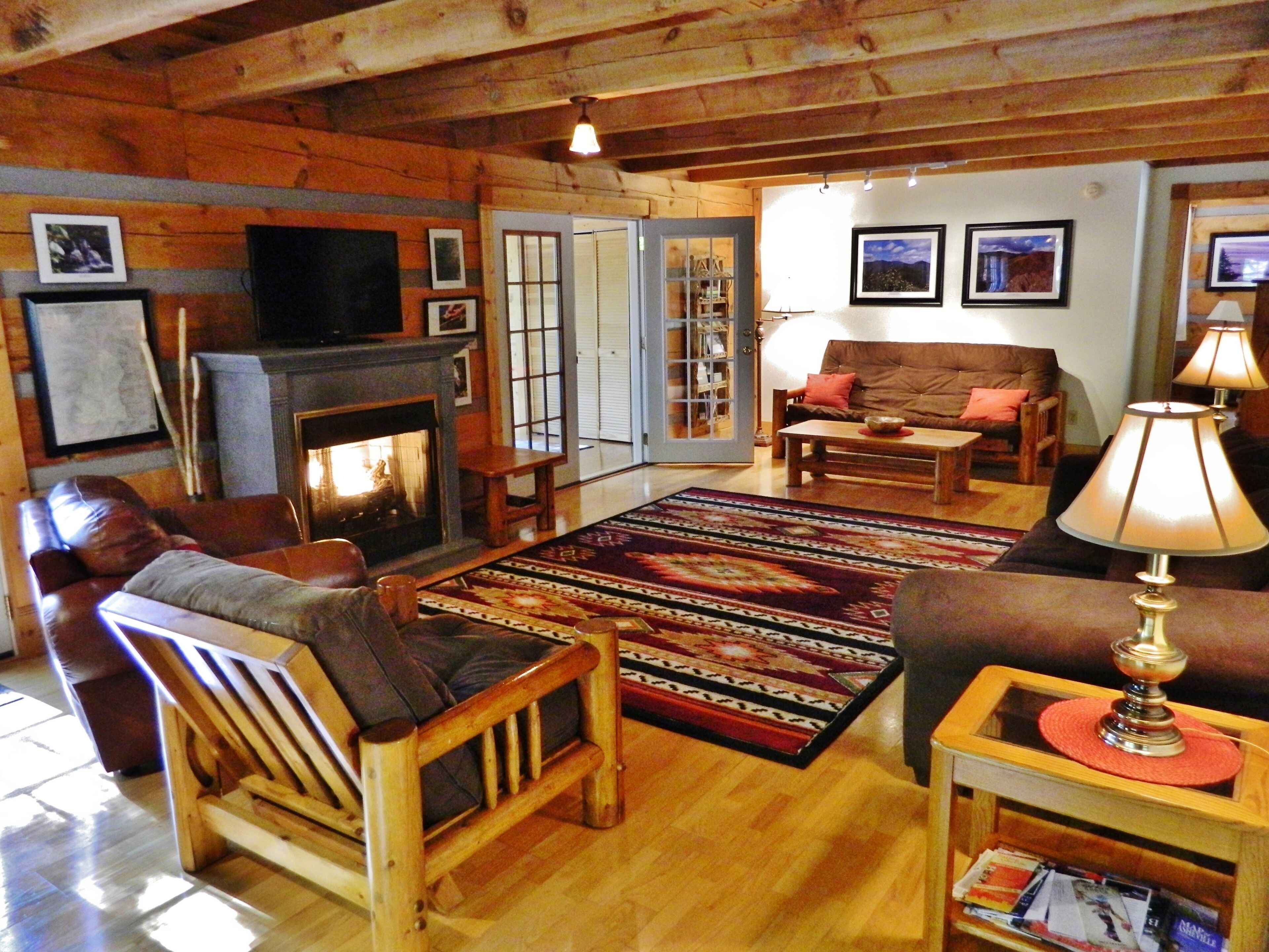 Una sala de estar acogedora con chimenea, muebles de cuero y suelo de madera.