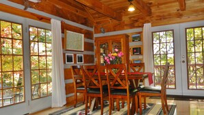 Une salle à manger en bois avec une grande table, des chaises et un buffet décoratif.