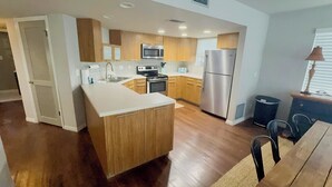 A modern kitchen with wooden cabinets, stainless steel appliances, and a central island. - AVAIL LABOR DAY WKEND - Steps to Beach - 3BR/3BA - Sleeps 8 - Garage (Palm Coast)