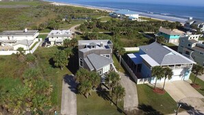 An aerial view of a coastal residential area with houses, a beach, and a clear sky. - AVAIL LABOR DAY WKEND - Steps to Beach - 3BR/3BA - Sleeps 8 - Garage (Palm Coast)