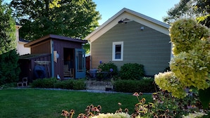 A house with a front yard, a small shed, and a garden with hydrangeas.