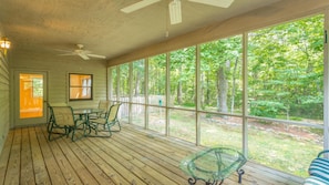 A covered porch with a table and chairs, large windows, and a ceiling fan. -  🏅5BR Large~22ppl-HOT TUB~ Easy checkout! 9 mi.Chatt (Lookout Mountain)