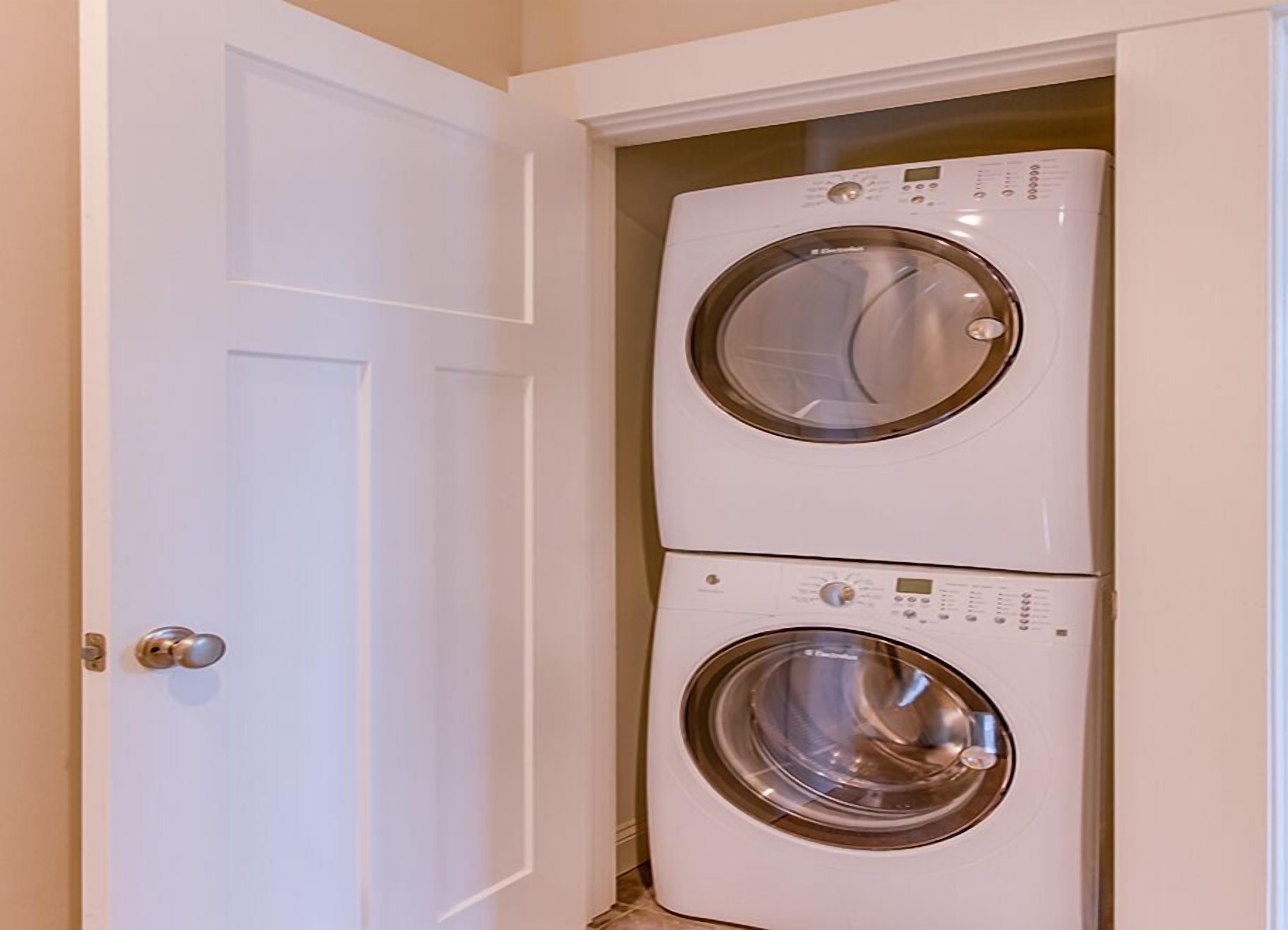 A laundry room with two stacked front-loading washing machines.
