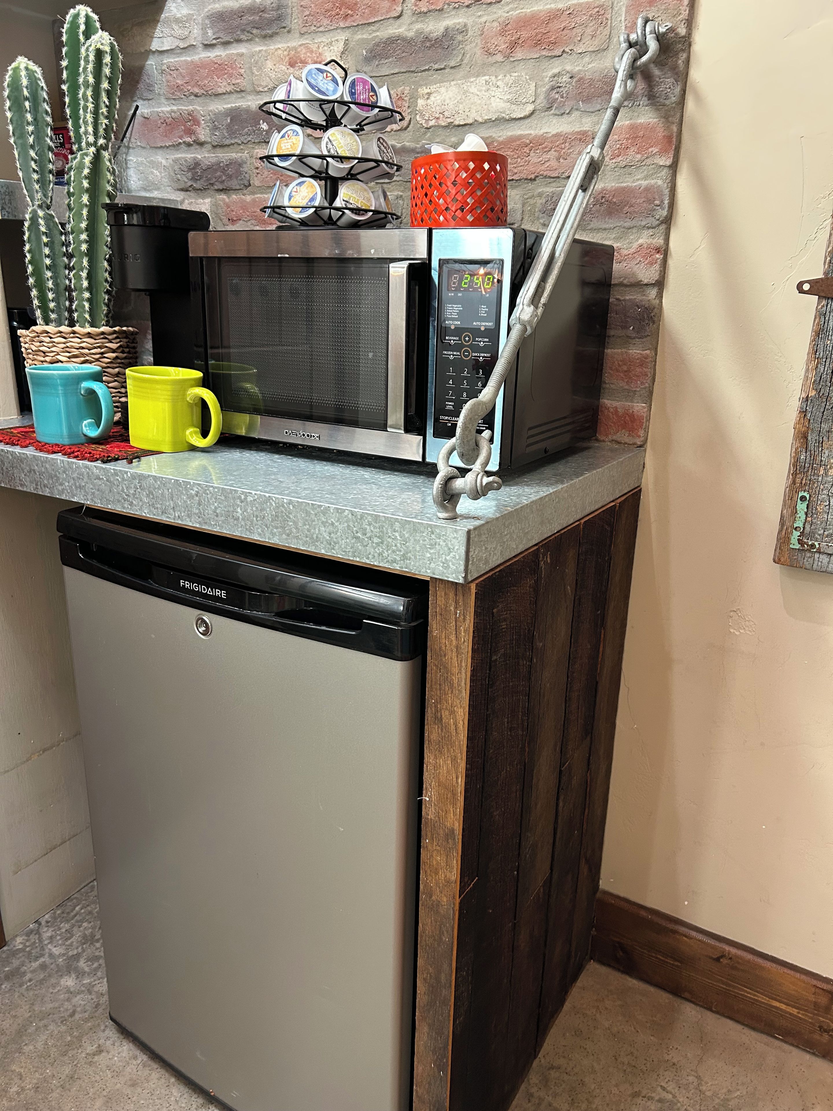 A kitchen with a built-in microwave, a coffee machine, and a dishwasher.