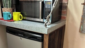 Une cuisine équipée d’un four à micro-ondes encastré, d’une machine à café et d’un lave-vaisselle.