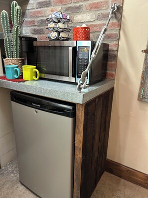 Een keuken met een ingebouwde magnetron, een koffieapparaat en een vaatwasser.
