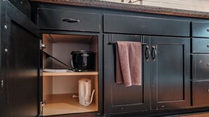 A kitchen with dark cabinetry, a countertop, a coffee maker, and a kettle. - LOFT · PNW Scenic Loft, with AC !Enjoy your private getaway today! (Philomath)