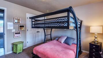 Cozy bedroom with a bunk bed, nightstand, and mirror.