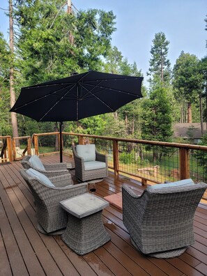 A wooden deck with wicker furniture and a large umbrella.