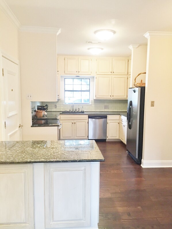 A kitchen with white cabinets, a stainless steel refrigerator, a dishwasher, and a granite countertop. - Lovely Home Steps From Dickies/Museums/Will Rogers/Cultural Dist and 2m From DT (Fort Worth)