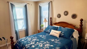 Une chambre à coucher avec un grand lit, une tête de lit en bois et une table de chevet avec une lampe.