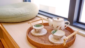 A tea set on a woven tray by a window with a cushion. - Pottery Flower B&B (Jiji)