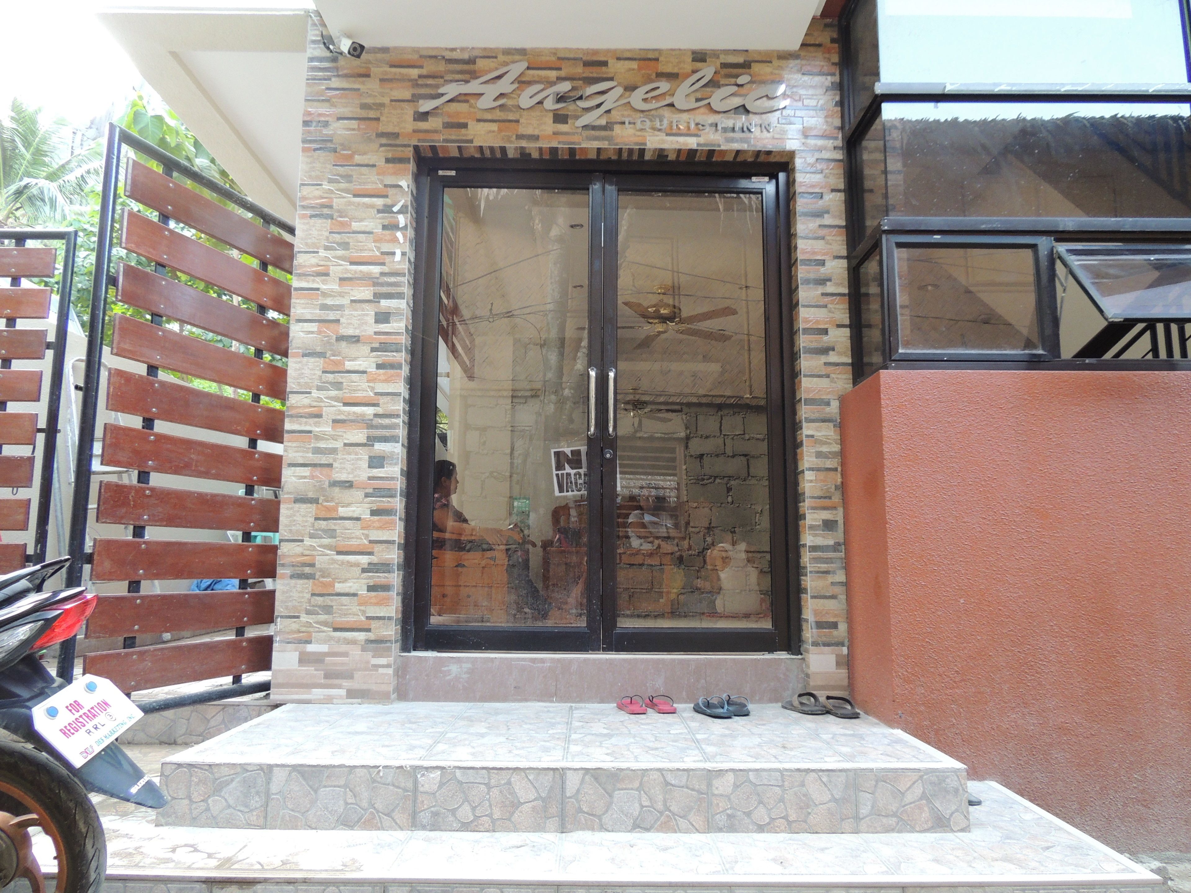 A storefront with a sign reading "Angelic Tourism" and a glass door entrance.