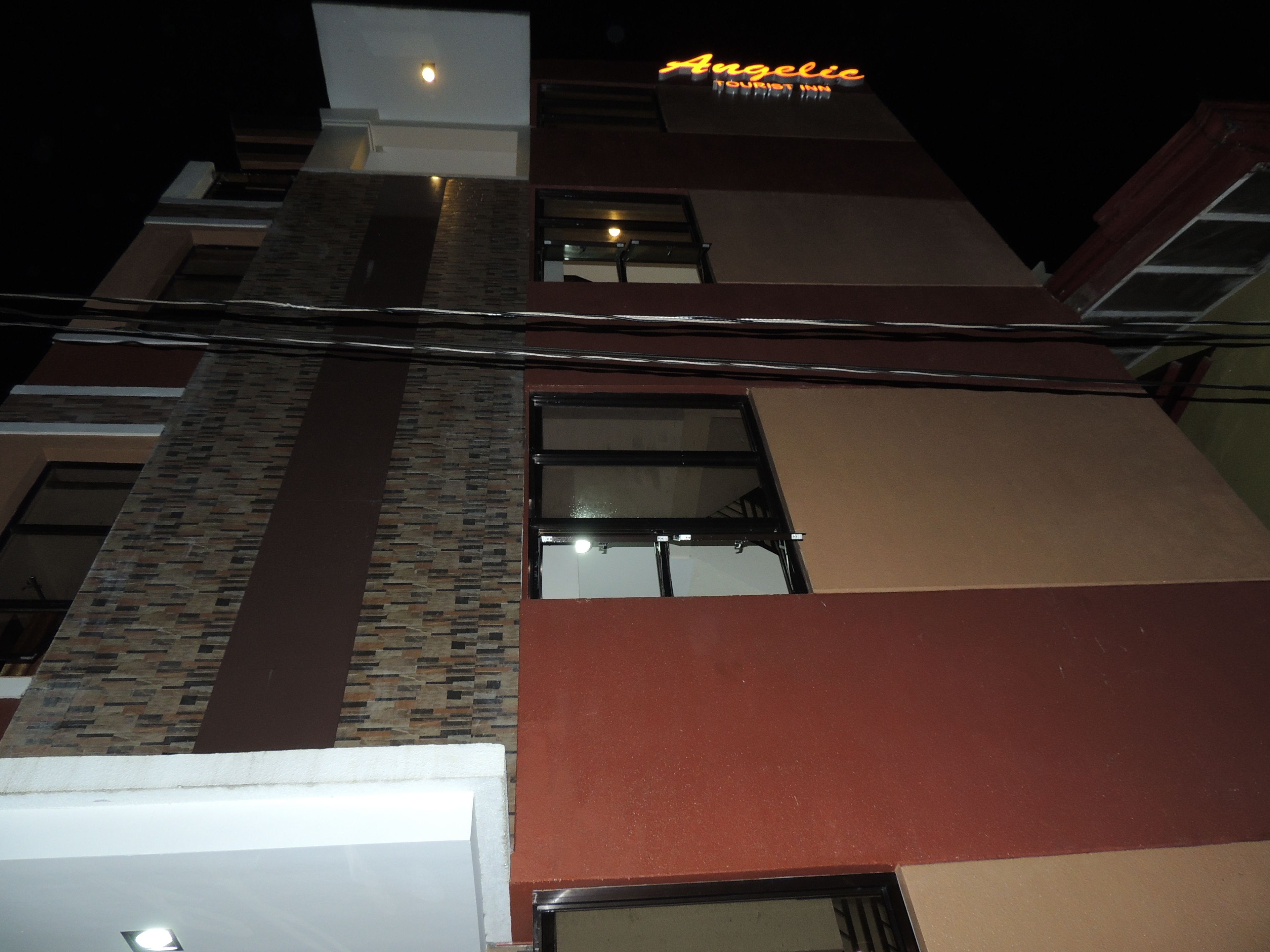 A multi-story building with a sign reading "Angelic Tourist Inn."