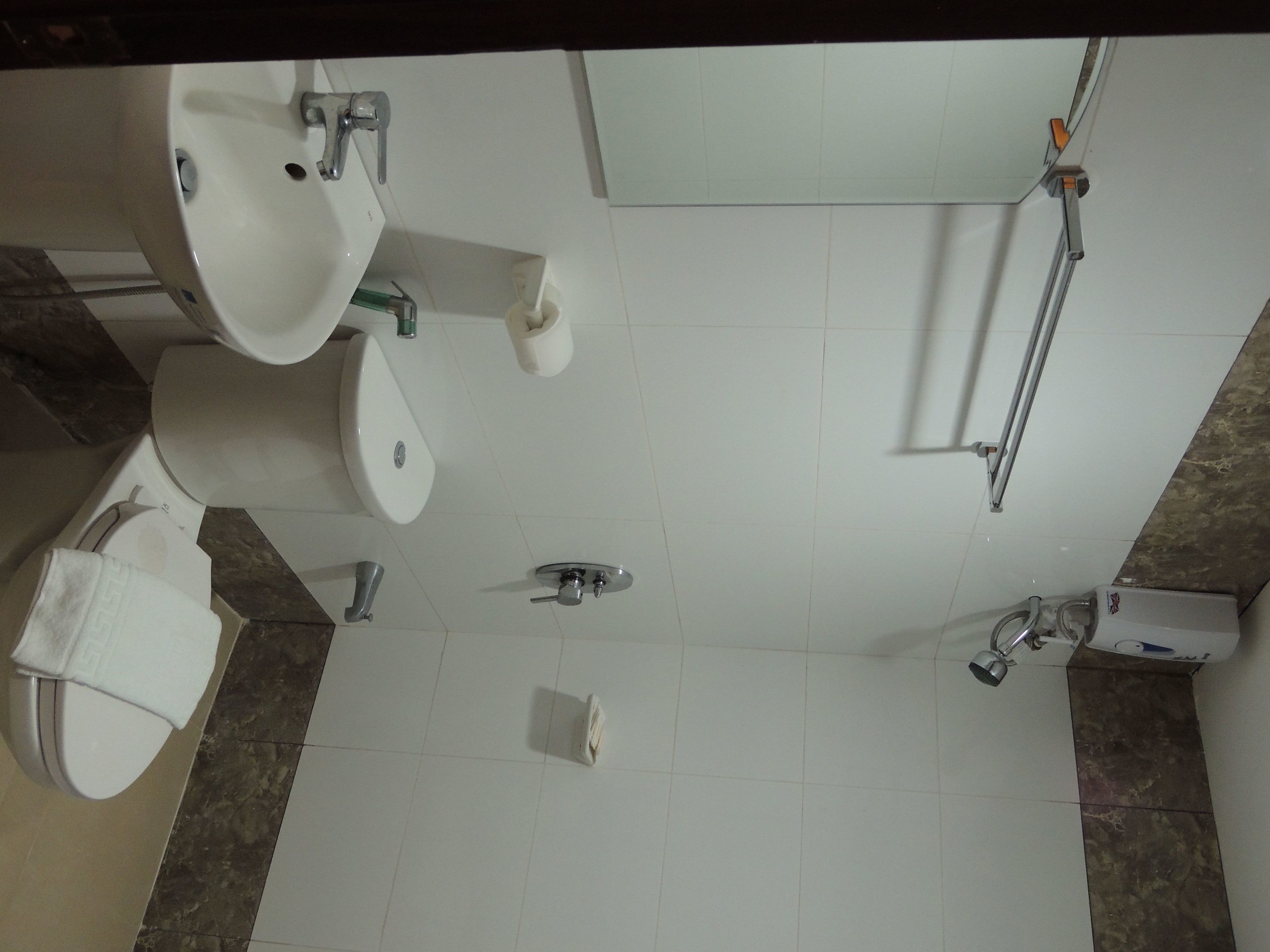 A bathroom with a sink, toilet, bidet, and shower.