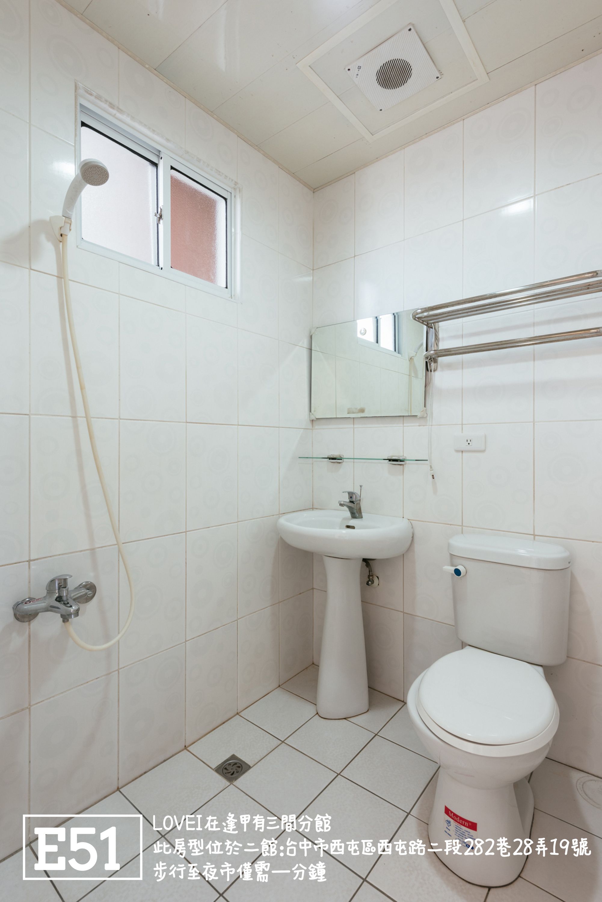 Een compacte, schone badkamer met toilet, wastafel en douche.
