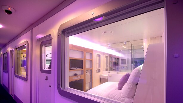 A train car with a window view of a bedroom, a small bathroom, and a television. - YotelAIR London Gatwick (Gatwick)