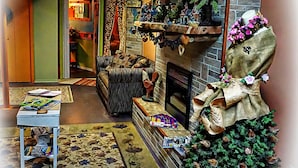 Una sala de estar acogedora con chimenea, un sofá y un árbol de Navidad.