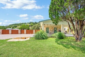 A house with a stone exterior, a green door, and a well-maintained lawn. - Artista I 2/2 with New Pool, Hot tub,  Pool Table (Wimberley)
