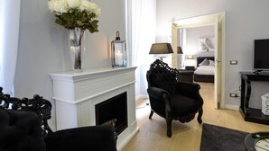 A modern living room with a fireplace, a black armchair, and a television. - Belsiana Apartment - Two Bedroom Apartment, Sleeps 6 (Roma)